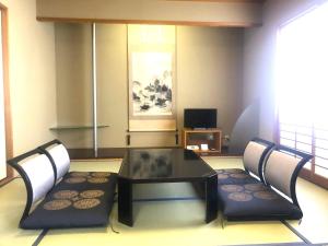 uma sala de estar com uma mesa e duas cadeiras em Grand Xiv naruto the lodge em Naruto