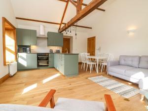 a kitchen and living room with a couch and a table at Chews Cottage in Pateley Bridge