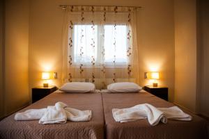 ein Schlafzimmer mit 2 Betten und Handtüchern darauf in der Unterkunft Gerasimos Dream House - 7 Minutes from the Airport in Lakíthra