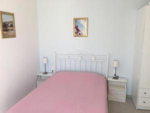 a bedroom with a bed with a pink blanket at Nikoleta Rooms in Tinos Town