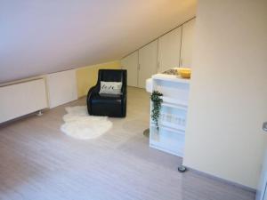 a room with a black chair and a white cabinet at Über den Dächern von Mörfelden-Walldorf in Mörfelden-Walldorf
