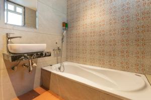 a bathroom with a white tub and a sink at The Royal Pavilion, Kolhapur in Kolhapur