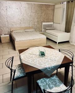 ナポリにあるA casa e Matildeのベッド2台、テーブル、椅子が備わる客室です。