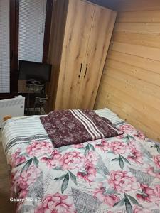 Un dormitorio con una cama con flores rosas. en Etno selo EKO POGLEDI en Požega