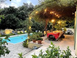 une terrasse avec une table et une piscine dans l'établissement Villa avec piscine en Provence, à Sauveterre