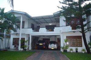 a house with two cars parked in the garage at The Kings Villa. in Wattala
