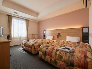 Voodi või voodid majutusasutuse Gamagori Hotel toas