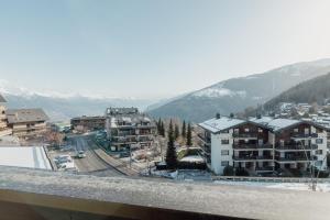 - une vue sur une ville avec des bâtiments et des montagnes dans l'établissement Charmant studio avec une vue imprenable, à Nendaz