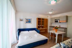 ein Schlafzimmer mit einem Bett und einem Tisch sowie eine Küche in der Unterkunft Monte Carlo Terrace, frontière Monegasque appartement vue mer in Beausoleil