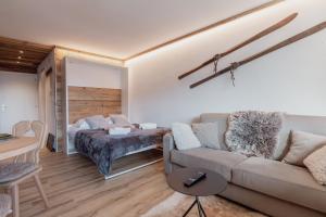 - un salon avec un canapé et un lit dans l'établissement Charmant studio avec une vue imprenable, à Nendaz