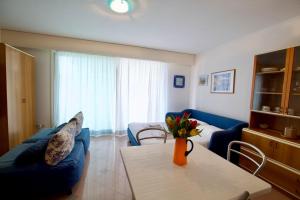ein Wohnzimmer mit einem blauen Sofa und einem Tisch in der Unterkunft Monte Carlo Terrace, frontière Monegasque appartement vue mer in Beausoleil