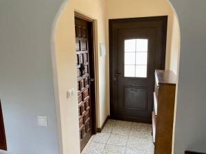 un couloir avec une porte noire et une fenêtre dans l'établissement Chalet privado, à San Juan de Alicante