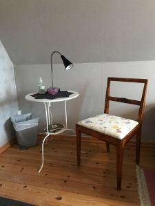 einen Tisch mit einer Lampe, einem Stuhl und einem Tisch mit einer Lampe in der Unterkunft B&B Hannåsa Gård in Hammenhög