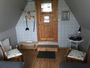 een kamer met een houten deur en een tafel en stoelen bij B&B Hannåsa Gård in Hammenhög