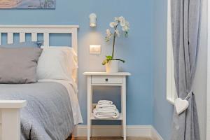a blue bedroom with a bed and a table with towels at PR APARTMENT - FIUMICINO ROME AIRPORT 9 Min - in Fiumicino