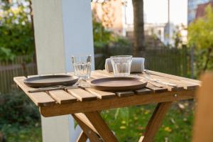 a wooden table with two plates and glasses on it at City Apartments Gerlingen in Gerlingen