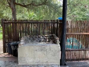 una recinzione con una fontana in pietra di fronte a una recinzione di Letaba Waterfront Lodge a Letaba Wildlife Reserve