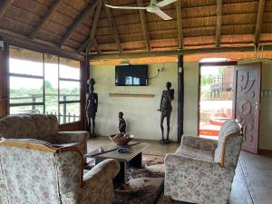 un soggiorno con 2 sedie, un tavolo e una TV di Letaba Waterfront Lodge a Letaba Wildlife Reserve