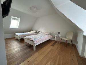 Schlafzimmer im Dachgeschoss mit 2 Betten und einem Stuhl in der Unterkunft La Casa Gialla in Verden