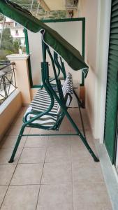 a green chair sitting on a balcony at Oasis Hostel in Himare