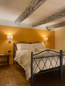 a bedroom with a bed with a yellow wall at Case Così Apartments - Napoli in Naples