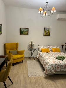 a bedroom with a bed and a yellow chair at Cozy house with backyard at Iraklio Attikis in Athens