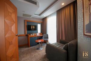 FOUR SEVEN HOTEL في إسطنبول: غرفة في الفندق بها كرسي وطاولة ومرآة