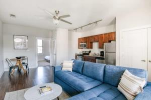 a living room with a blue couch and a kitchen at CozySuites Music Row Chic 1BR w free parking 57 in Nashville