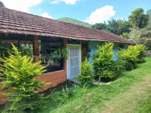 uma pequena casa com árvores em frente em Sítio das Pedras em Matias Barbosa