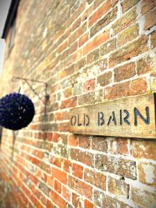 an old barn sign on the side of a brick building at The Old Barn - Bramble Farm Cottages in Ferndown