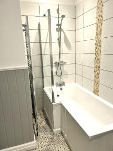 a bathroom with a tub and a shower at The Old Barn - Bramble Farm Cottages in Ferndown