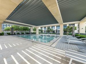een zwembad in een gebouw met luifel en banken bij Luxurious 2BR Apt in Downtown Pool and Gym Access in Dubai