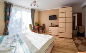 a bedroom with a bed and a window and a desk at Willa JANTAR in Dębki