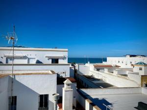 una vista de los tejados de los edificios y del océano en MyChoice Pitiusa by Bossh! Apartments, en Rota