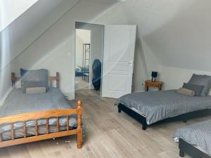 um quarto com 2 camas e um espelho em Le Gîte de la Forêt - Montmacq em Thourotte