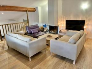 a living room with two white couches and a table at Maison Tulipe in Puivert