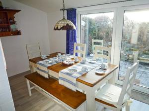 新哈林格西爾的住宿－Ferienhaus Treibholz II，一间带桌椅和窗户的用餐室