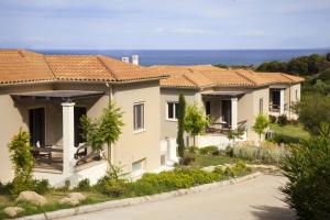 een rij huizen met de oceaan op de achtergrond bij Ploes Villas in Skafidia