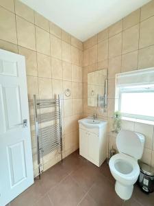 uma casa de banho com um WC, um lavatório e uma janela em Contemporary Urban Retreat in Central Reading em Reading