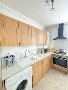 a kitchen with a washing machine and a sink at Contemporary Urban Retreat in Central Reading in Reading