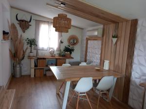 ein Esszimmer mit einem Holztisch und weißen Stühlen in der Unterkunft Villa 3 chambres avec jacuzzi in Saint-Maximin-la-Sainte-Baume