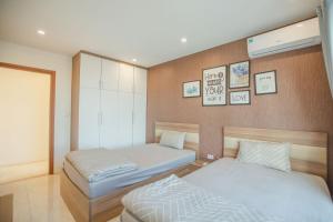 een slaapkamer met 2 bedden en een muur met foto's bij Vân' House in Ha Long