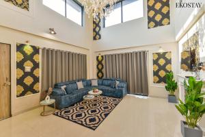 EKO STAY Gold - Gatsby Villa في لونافالا: غرفة معيشة مع أريكة زرقاء وطاولة