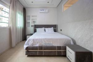 1 dormitorio con 1 cama grande con sábanas blancas en Oasis Urbaine au centre de Fès, en Fez