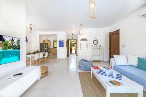 een woonkamer met een blauwe bank en een tafel bij Villa Greco Mare #40 in Protaras