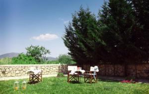 una mesa y sillas en un patio junto a una pared de piedra en Porto Nirikos, en Lefkada