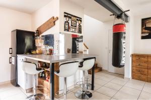 a kitchen with a bar with stools in a room at Villa des Palmiers, Chambre 2, Lit double in Villeneuve-sur-Lot
