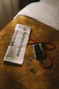 a camera and a newspaper on a bed at 2Places Soul in Lörrach