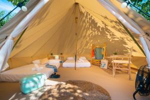 Zelt mit 2 Betten und einem Tisch in der Unterkunft Kampaoh Oyambre in El Tejo