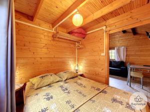 1 dormitorio con 1 cama en una cabaña de madera en Scheffléra - Bungalow aux Makes - Saint-Louis, en Saint-Louis